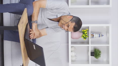 Vertical-video-of-Old-man-making-video-call-on-laptop.-Happy-and-waving.